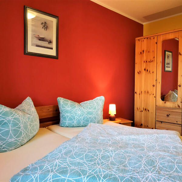 Schlafzimmer mit Doppelbett und großem Kleiderschrank